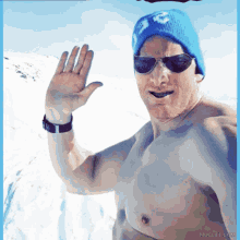 a shirtless man wearing a blue hat and sunglasses is waving