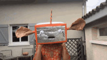 a man wearing a robot costume stands in front of a building