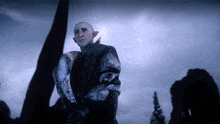 a bald man with elf ears is standing in front of a building