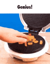 a person is putting gummy bears into a waffle maker with the words " genius " above it