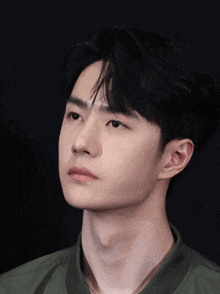 a close up of a young man 's face with a dark background
