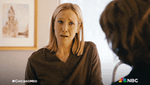 a woman talking to another woman with #chicagomed written on the bottom right