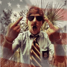 a man wearing sunglasses and a striped tie giving the middle finger