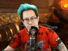 a man with blue hair and glasses is sitting in front of a microphone with the words turn behind him