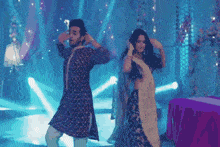a man and a woman are dancing on a stage in front of a crowd .