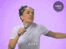 a woman is singing into a microphone and saying the name amy