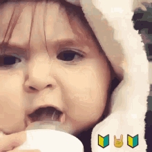a baby is drinking from a bottle with a sign that says i love you