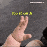 a baby 's hand is reaching out towards the camera with a foreign language .