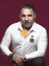 a man wearing a white shirt and a watch is sitting down