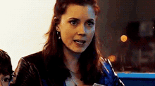 a woman in a black leather jacket is sitting at a table with a child .