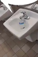 a bottle of kleenex sits in a sink