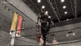 a woman stands in a wrestling ring with a banner that says god 's eye on it