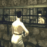 a woman in a white dress stands in front of a window looking at her reflection