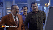 three men are standing in front of a screen that says sony liv