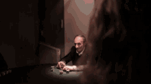 a man sitting at a table with a glass of wine and poker chips