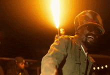 a man wearing a hat and sunglasses holds a torch in his hand