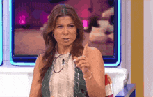 a woman is sitting in front of a television and giving a thumbs up sign .