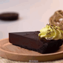 a slice of chocolate cake with yellow frosting on a wooden plate with the words mr.cakes below it
