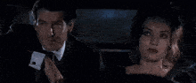 a man in a suit and tie is standing in a dark room .