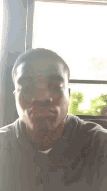 a man taking a selfie in front of a window with his mouth open