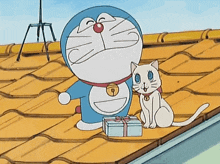 doraemon and a white cat are on a roof with a gift box