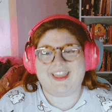 a woman wearing pink headphones and glasses smiles
