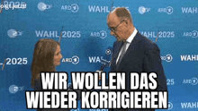 a man in a suit is talking to a woman in front of a blue background .