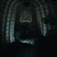 a dark room with a light shining through a doorway