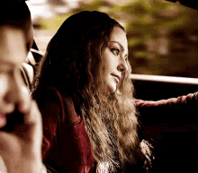 a woman is sitting in the back seat of a car with a man .