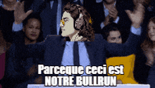 a man in a suit and tie stands in front of a crowd with the words " parceque ceci est notre bullrun "