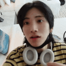 a close up of a person wearing headphones and a mask on their face .