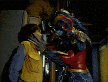 a woman wearing green gloves is being held by another person