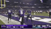 a group of football players are standing on a field during a game .
