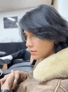 a woman with long black hair is sitting in a chair with a pillow on her neck .