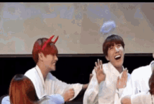 a group of people are sitting around a table laughing .