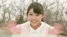 a young woman in a white fur coat smiles for the camera