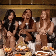 a group of women sit on a couch with a happy anniversary sign on the table