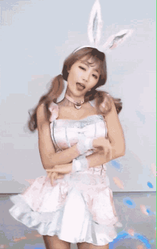 a woman in a pink dress with bunny ears is dancing