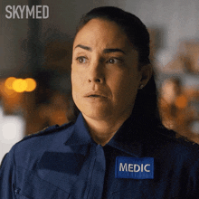 a woman is wearing a blue uniform with a patch that says medic