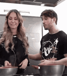 a man and a woman are cooking in front of a brastem refrigerator