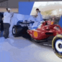 a red race car is parked next to another race car