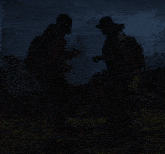 two people are standing in the dark and one has a sticker on his back that says ' ec '