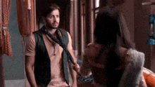 a man and a woman are standing next to each other in a room .