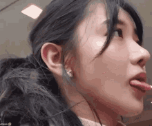 a close up of a woman 's face with her tongue hanging out .