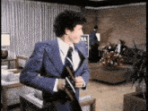 a man in a suit and tie is standing in a living room