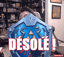 a man is holding a shield that says desole on it