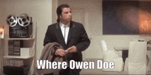 a man in a suit is standing in a living room with the words `` where owen doe '' written above him .