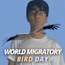 a man with a bird on his shoulder and the words world migratory bird day below him
