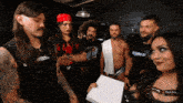 a group of wrestlers are standing around a woman who is holding a box that says ' fears of ' on it