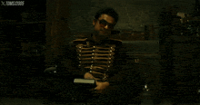 a man with a tattoo on his arm is wearing sunglasses and a military jacket